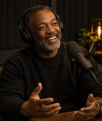 A guest laughing mid-interview at a studio microphone.